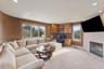 Carpeted living room with a tile fireplace and built in desk