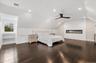 Bedroom with vaulted ceiling, a ceiling fan, dark wood finished floors, recessed lighting, and a glass covered fireplace