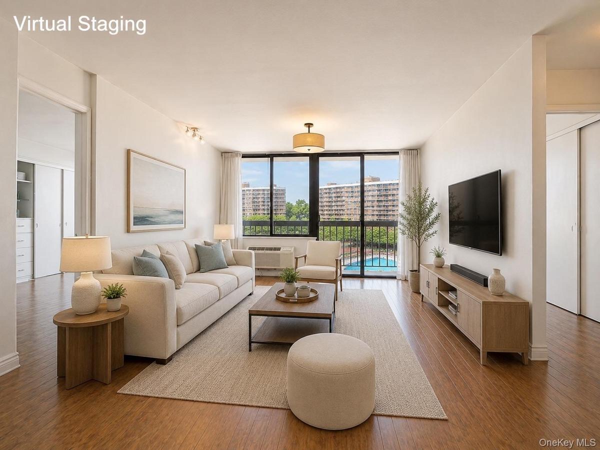 Sun-filled and spacious living room featuring desirable southern exposure, new windows, and updated heating/AC systems. Enjoy open views overlooking t