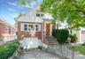 Bungalow-style house featuring brick siding, driveway, and an attached garage