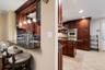Kitchen featuring dark wood cabinetry, stainless steel appliances, a granite countertop, and a breakfast bar with pendant lighting
