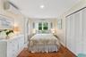 Bedroom with an AC wall unit, wood finished floors, a closet, recessed lighting, and crown molding