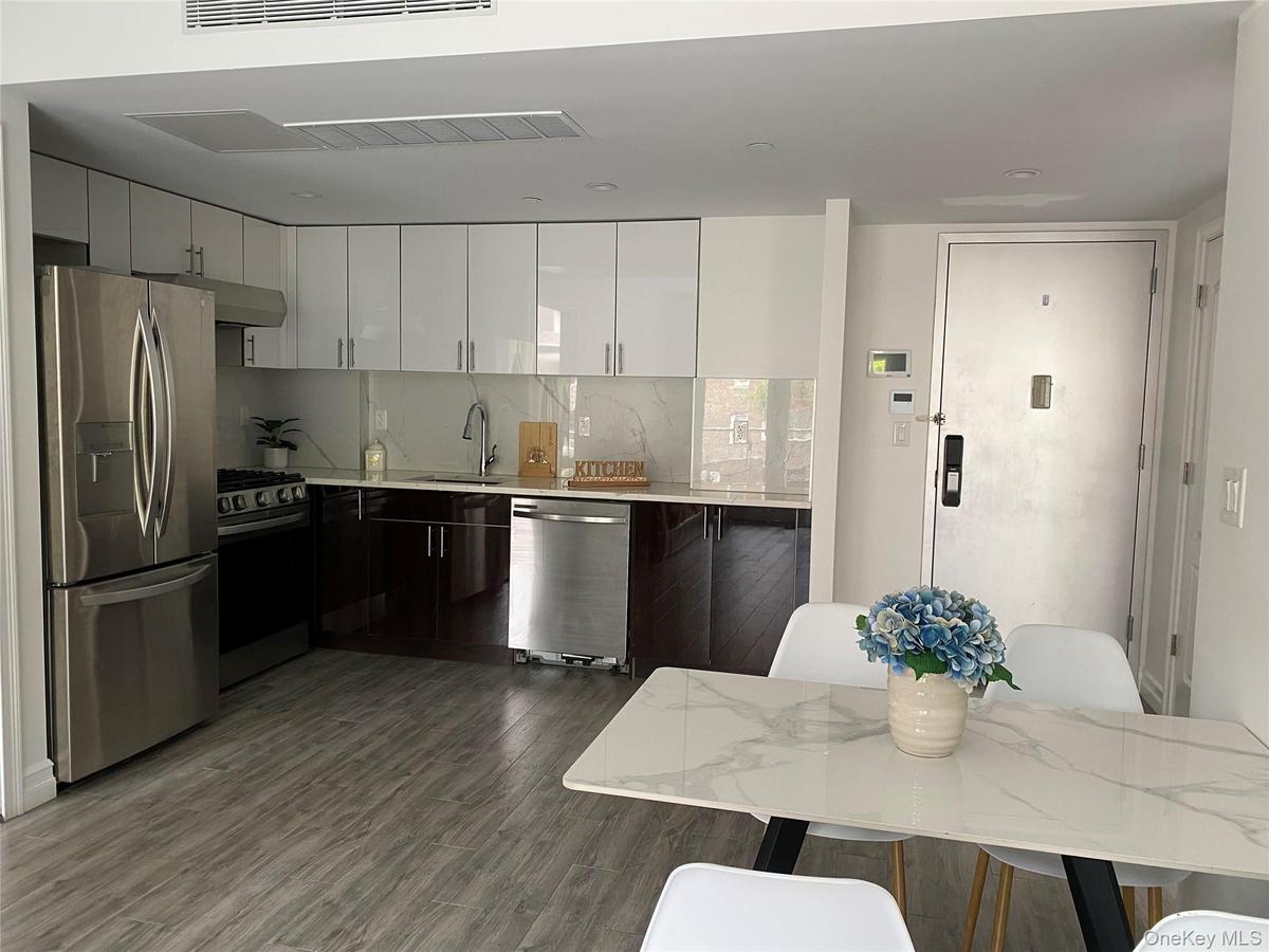 Kitchen with white cabinets, stainless steel appliances, modern cabinets, and backsplash