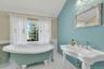 Full bath with a freestanding champaigne soaker bath and vaulted ceiling