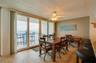 A spacious dining area with sliding glass doors offers direct access to the balcony and sweeping coastal views perfect for gathering with friends or e