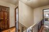 Hall with wood-type flooring and an upstairs landing