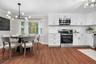 Newly renovated kitchen and dining area featuring quartz counters, stainless steel appliances, and a bay window that fills the space with natural ligh