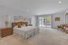Light-filled room featuring plush carpeting, recessed lighting, and a sliding glass door opening to an outdoor deck