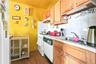 Kitchen with light countertops, backsplash, dark wood-style floors, under cabinet range hood, and white appliances
