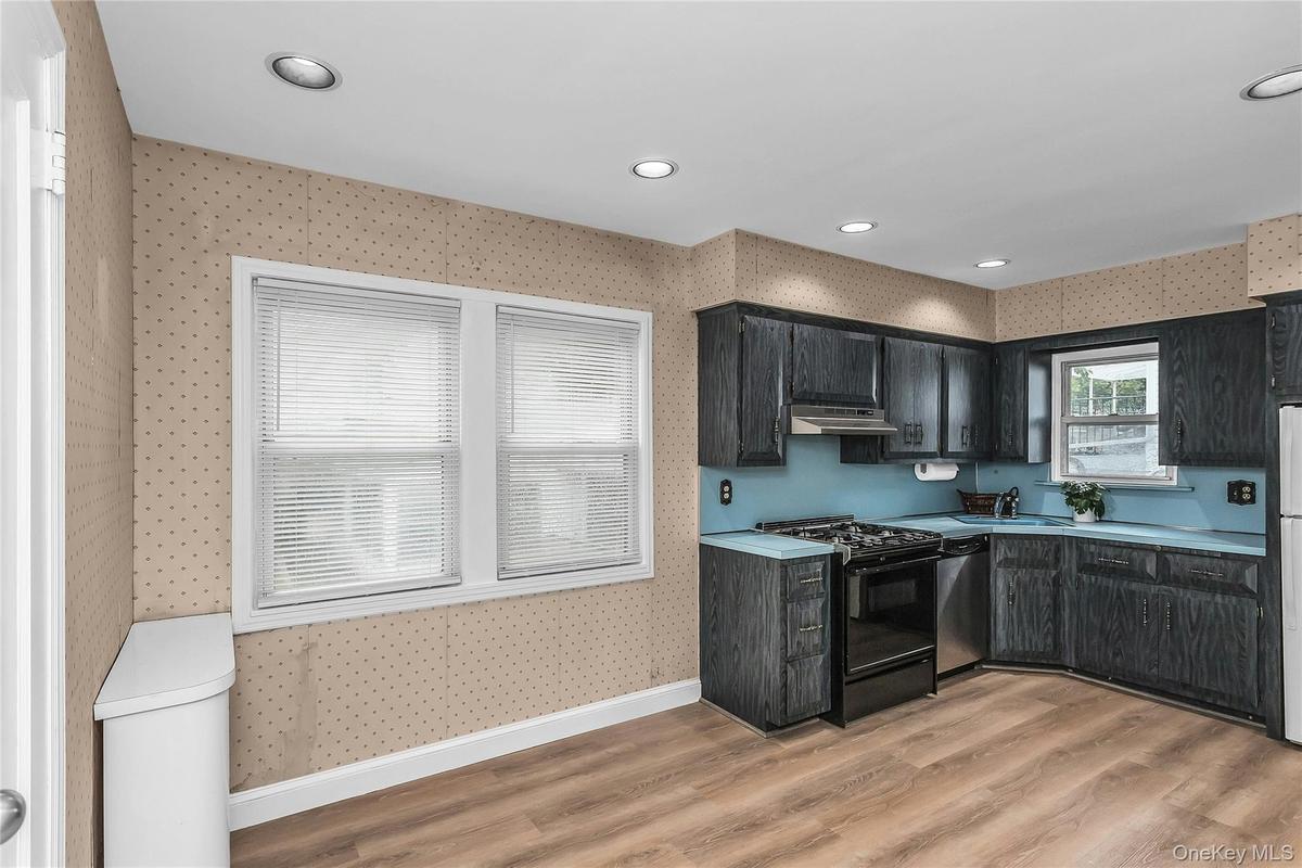 Kitchen featuring dark wood-finish cabinetry, and a full suite of appliances EIK