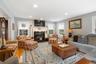 Living room with wood finished floors, recessed lighting, and a glass covered fireplace
