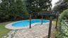 Oval-shaped swimming pool with concrete surround