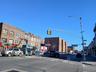 View of asphalt road featuring traffic lights, sidewalks, street lighting, and curbs