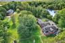 View from above of property with a heavily wooded area and a large body of water