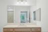 Oversized light wood vanity with new quartz countertops, under mount porcelain sink and Kohler Faucet