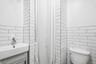 1st Floor Apartment Bathroom features white subway tile wainscoting and a white toilet
