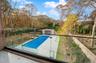 View of pool featuring a fenced backyard, an outbuilding, and a balcony
