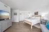 Bedroom with light wood finished floors, baseboards, visible vents, and a closet