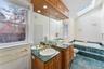 Full bathroom featuring a garden tub, a skylight, vanity, healthy amount of natural light, and lofted ceiling