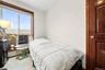 Bedroom featuring vaulted ceiling and a baseboard heating unit