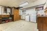 Laundry area featuring light flooring, plenty of natural light, wooden walls, and separate washer and dryer