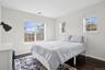 Bedroom with visible vents, dark wood-style flooring, and baseboards
