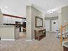 View to the entryway foyer and garage access. Open-plan kitchen to the left.