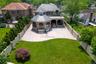 Back of property with french doors, a high end roof, a patio area, stone siding, and a fenced backyard