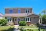 Two-story residence featuring tan shingle siding and a prominent bay window