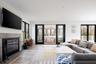 Living room featuring plenty of natural light, light wood-type flooring, a fireplace, and ceiling fan