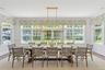 Sunroom featuring ornamental molding, a wainscoted wall, wood finished floors, and a healthy amount of sunlight