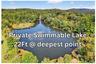 Drone / aerial view of a large body of water and a heavily wooded area