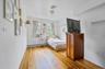 Bedroom with light wood-style flooring and a baseboard radiator