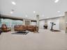 Beautiful basement with full-sized windows, multiple large closets, recessed lighting, all neutral carpeting and slider to a covered patio.