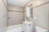 Full bath with bathing tub / shower combination, vanity, and tile walls