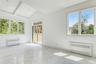Spare room featuring radiator heating unit, light marble finish flooring, and lofted ceiling