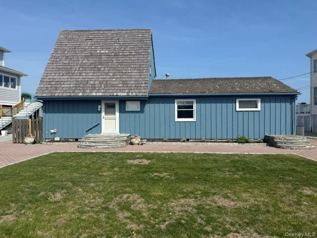View of front of home featuring a front yard and board and batten siding