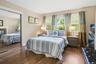 Bedroom featuring dark wood finished floors, wooden walls, and a closet