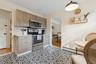 Kitchen featuring stainless steel appliances, light countertops, baseboard heating, backsplash, and crown molding