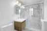 Beautifully renovated with striking marble finishes, the third-floor hall bath features a spacious glass-enclosed shower, contemporary vanity, and ele