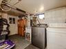 Laundry area featuring a utility sink, exposed piping, and a glass-paneled door
