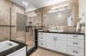 Bathroom with tile walls, vanity, a shower stall, recessed lighting, and a tub to relax in