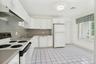 Tiled kitchen floor with window overlooking the front and door to garage..