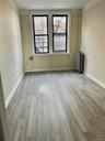 Spare room with radiator heating unit and light hardwood / wood-style flooring