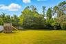 Fenced backyard view of scattered trees - level property