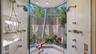 Glass-enclosed “outdoor” shower that offers breathtaking views of the outdoors featuring dual his-and-her shower heads, allowing both style and functi