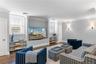 Living area with visible vents, baseboards, wood finished floors, and ornamental molding