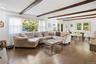 Living room with beamed ceiling and wood finished floors