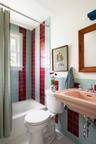 Bathroom featuring tile walls, tile patterned flooring, and shower / bath combo with shower curtain