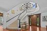 Entrance foyer with healthy amount of natural light, a decorative wall, decorative columns, crown molding, and stairs